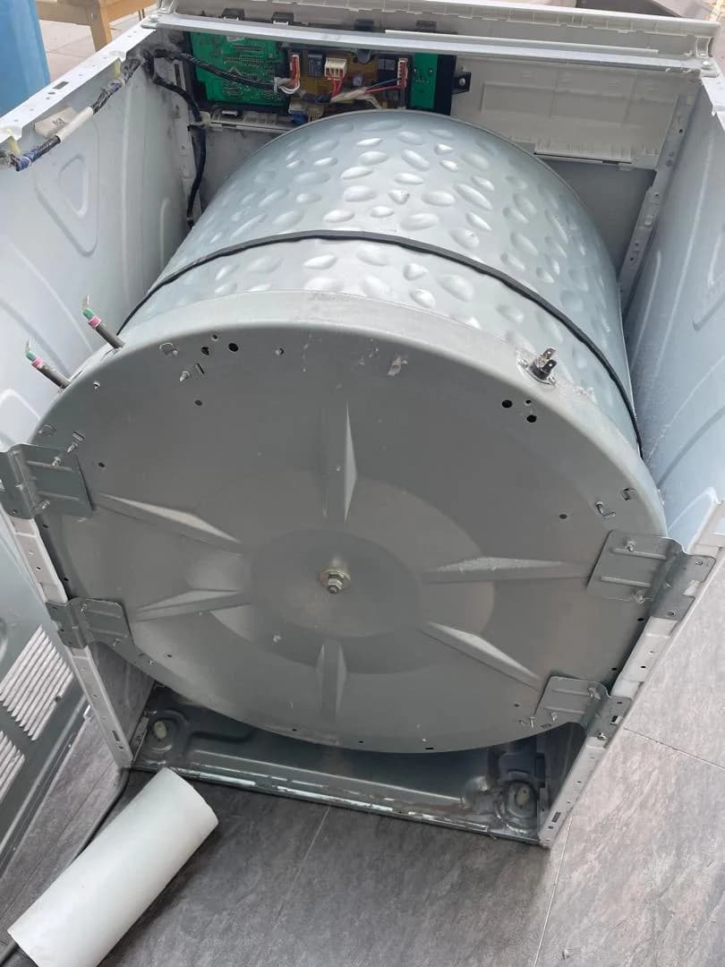 Dryer drum and drive belt exposed during disassembly