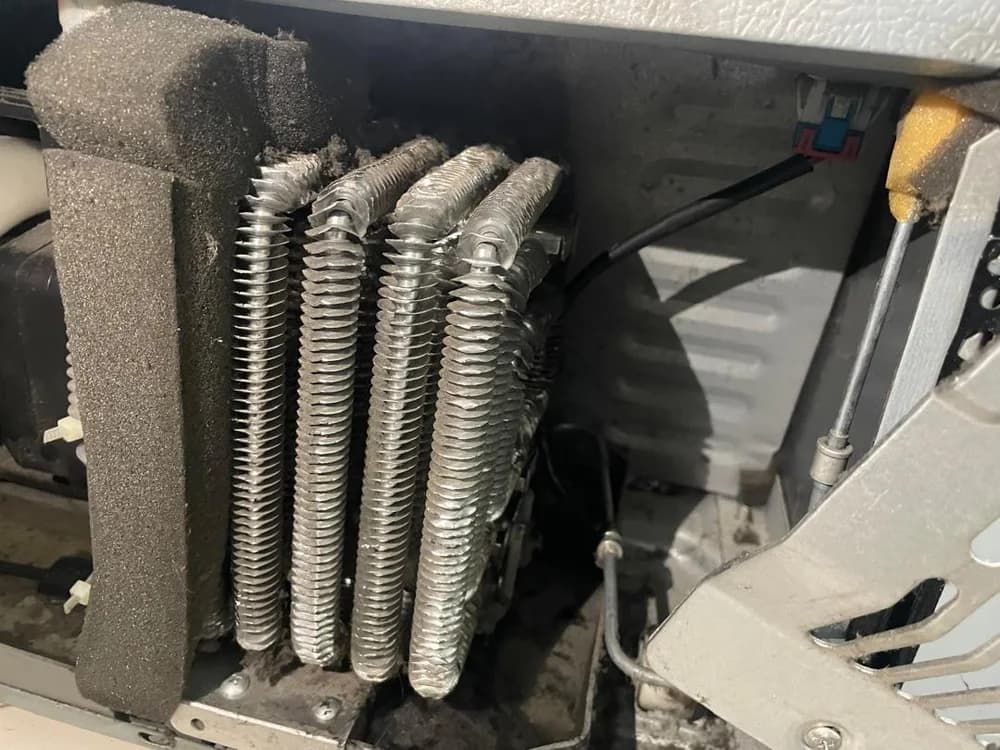 Close-up of refrigerator cooling coils and compressor compartment